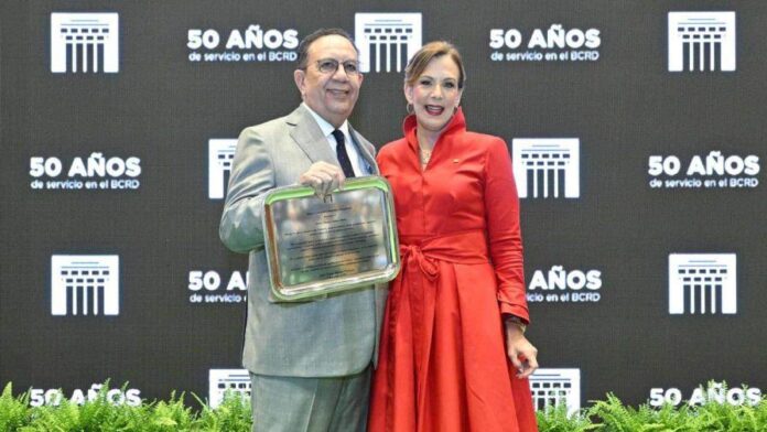 Héctor Valdez Albizu recibe el reconocimiento de la manos de la vicegobernadora del BCRD, Clarissa de la Rocha. (FUENTE EXTERNA)