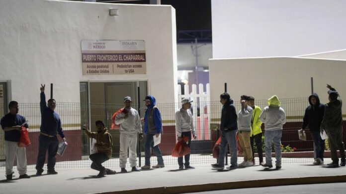 Migrantes deportados desde Estados Unidos, en el puente peatonal fronterizo de El Chaparral, en Tijuana, México, el 21 de enero de 2025. Las redadas antiinmigrantes en EE.UU. han logrado el arresto de más de 500 inmigrantes y un centenar de deportados. (AP)